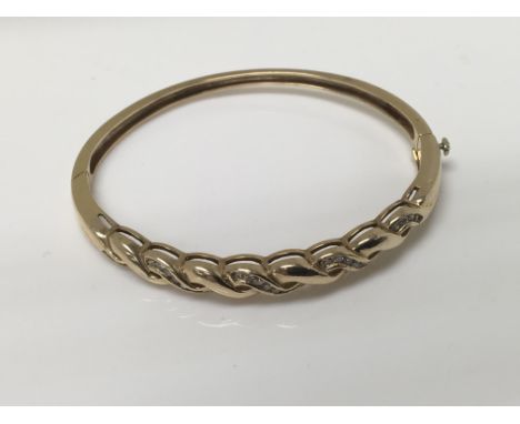 A 9 ct gold bangle inset with diamonds 16 grams
