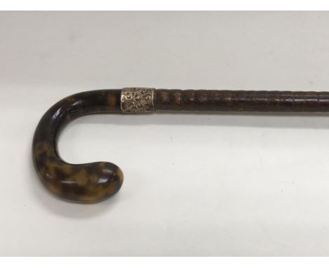 A tortoiseshell style handled walking stick.