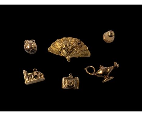 18ct gold fan charm, four 9ct gold charms including bell and camera and a 9ct gold church charm with lightCondition Report:18