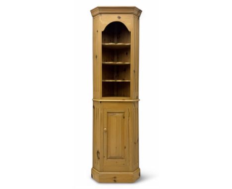 Early 20th century pine corner cabinet, projecting cornice over three shaped shelves, base fitted with single door enclosing 