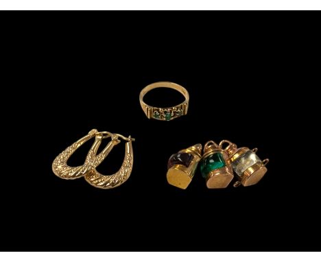 14ct gold three stone emerald ring, pair of 9ct gold hoop earrings and three 9ct gold ship's lantern charmsCondition Report:1