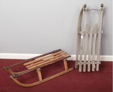 Two vintage wooden sledges with metal runners. H: 26cm, W: 89cm  