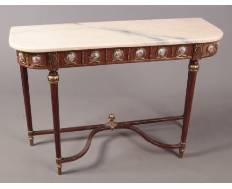 A modern marble top console table with Sevres style panels.  