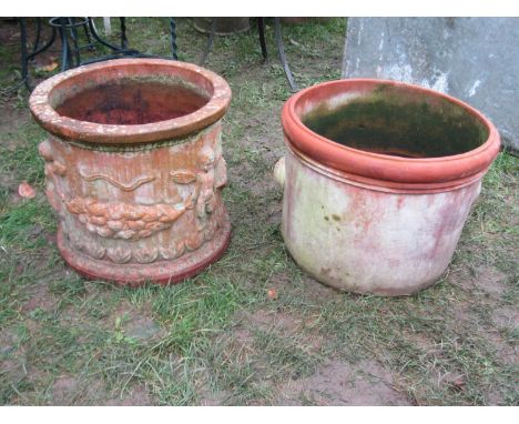A weathered squat cylindrical terracotta planter with repeating raised relief winged cherub and fruiting swag detail, 45 cm d