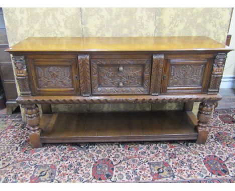 Good quality Old English style oak sideboard in the Elizabethan manner enclosed by two cupboards and two drawers over a pot s