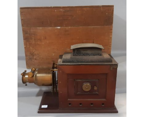 A Victorian Magic lantern projector in mahogany with brass mounts, large glass lens and tin chimney with original pine travel