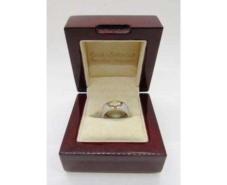 An 18ct white gold ring, set with a single bezel set marquise diamond, marked 750, 6.4g. Sold with ‘Diamonds In Pardise’, (Ca
