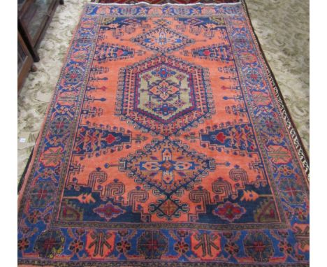 A Turkish Carpet with a central medallion flanked by two smaller on a predominantly peach ground and stylised floral border, 