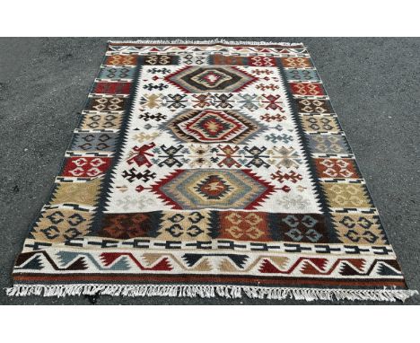 A Kilim Carpet with a central panel of three stepped radiating medallions with a border of square designs, 230cm 175cm approx