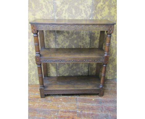 An old English oak three tier buffet with repeating carved frieze work, raised on turned supports, 123cm wide x 157cm high x 