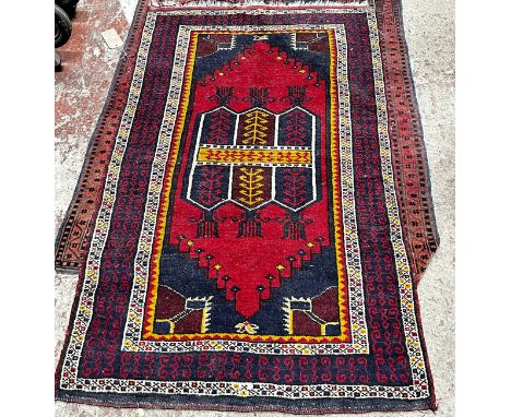 A Kazak style carpet with a central repeating rhombic pattern with a red panel and geometric borders, 164 x 97cm approx. 