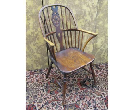 A 19th century mixed wood Windsor stick back armchair principally in elm, with pierced wheel splat 