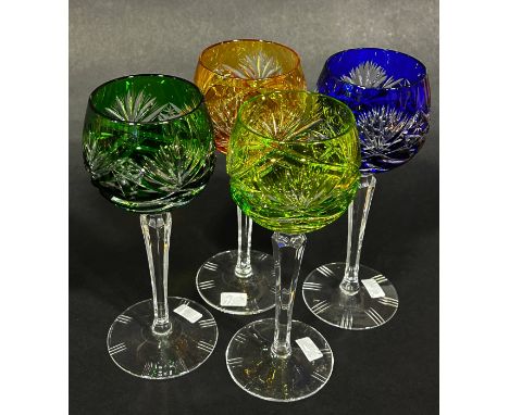 Four multicoloured cut glass hock glasses, blue, dark green, light green and amber, on slender hexagonal stems. 