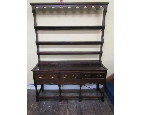 A small oak cottage dresser the base enclosed with three frieze drawers raised on turned supports, units by rails, the plate 