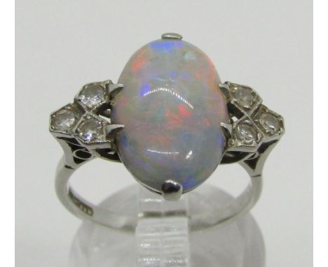 An antique platinum, opal and diamond dress ring, the central opal flanked with diamond-set shoulders, size L/M, 4.4g