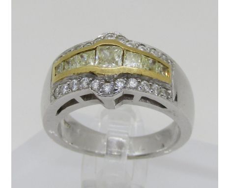 An 18ct white gold, fancy yellow and white diamond dress ring, with yellow gold mount enclosing seven graduating princess cut