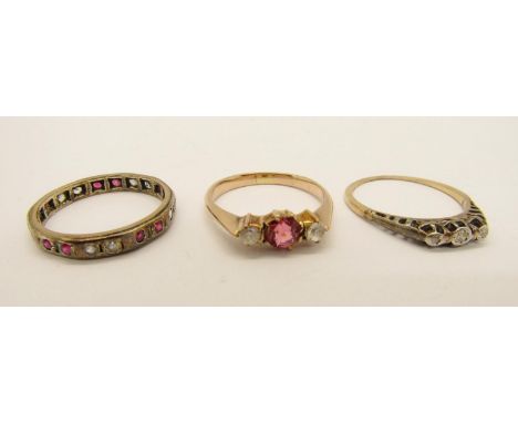 Group of three dress rings; a yellow metal three stone diamond ring (worn), a yellow metal paste set ring and a 9ct gem set e