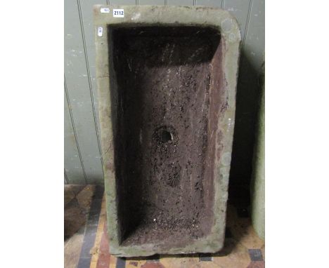 A shallow thick walled rectangular natural stone trough or sink with central drainage hole and single rounded corner, 92cm lo