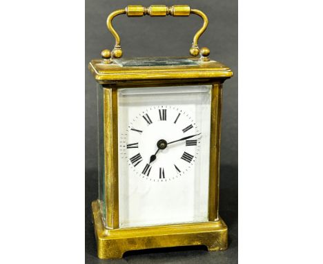 A brass cased carriage clock, the white enamel dial with black Roman numerals, 11 cm high 