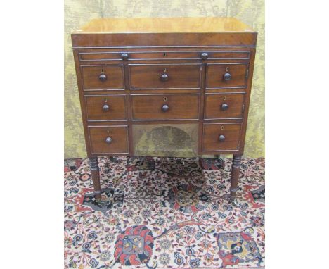 19th century mahogany gentleman's commode with rising lid, the front elevation enclosed by a series of drawers and cupboards,