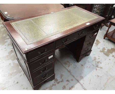 Reproduction mahogany twin pedestal desk with tooled green leather top and an arrangement of nine drawers below on bracket fe