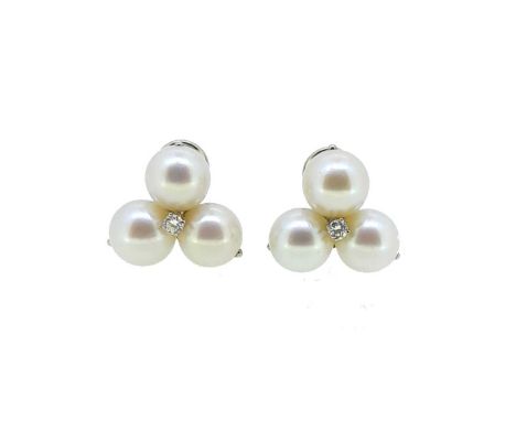 A pair of cultured pearl and diamond ear clips, each set with a central round brilliant cut diamond, estimated approximate to