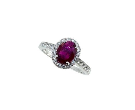 An 18ct gold Burmese ruby and diamond halo style cluster ring, claw set central oval faceted ruby, 7.96 x 5.93mm, surrounded 