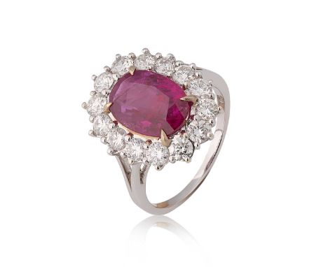A Burmese ruby and diamond cluster ring, oval faceted ruby, 10.67 x 7.92 x 3.96mm, surrounded by fourteen claw set round bril