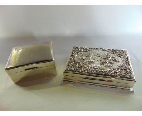 A sterling silver cigarette box, Thailand, the rectangular body with stepped foot, the hinged cover embossed with a decorativ