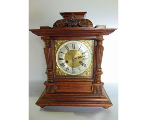 A late 19th century bracket clock, the oak case with split spindle mouldings enclosing a square brass dial with silvered chap
