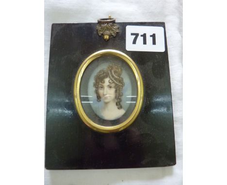 A 19th century miniature portrait of oval form showing a shoulder length study of a young woman with her hair in ringlets wit