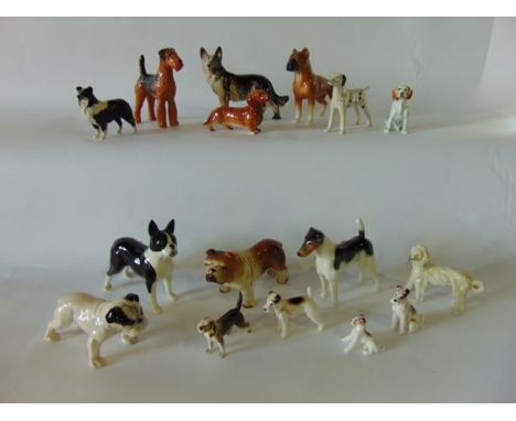 A quantity of various ceramic dogs including Sylvac models of a black and white boxer dog, airedale terrier, fox terrier, etc