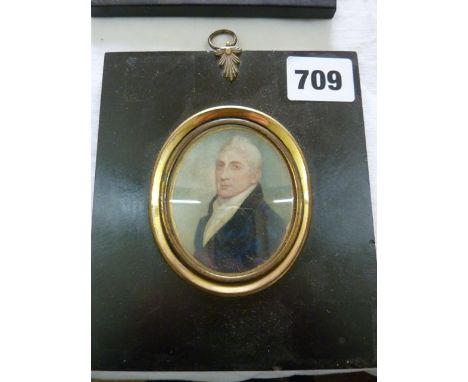 An early 19th century miniature portrait of oval form showing a white haired gentleman in blue coat and white cravat, 7 cm ma