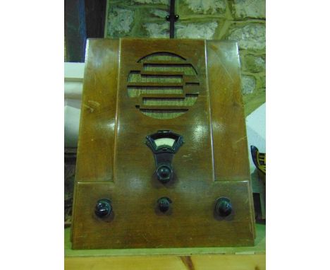 An early 20th century timber cased wireless radio set of tall rectangular form with pierced façade and further stepped detail