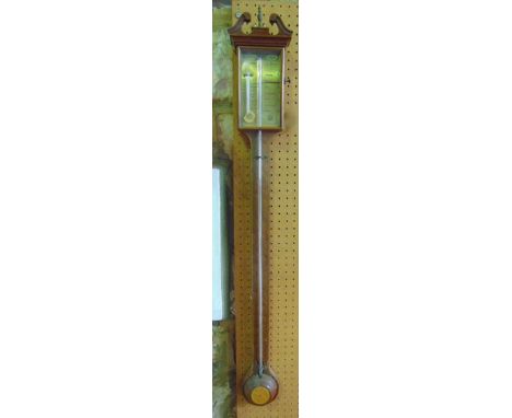 A reproduction mahogany stick barometer with brass dial, string banded and other inlaid detail, set beneath a swan neck corni