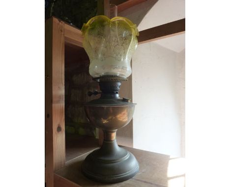 A brass oil lamp with British made burner supporting a good quality uranium tinted clear glass shade, the pinched and flared 