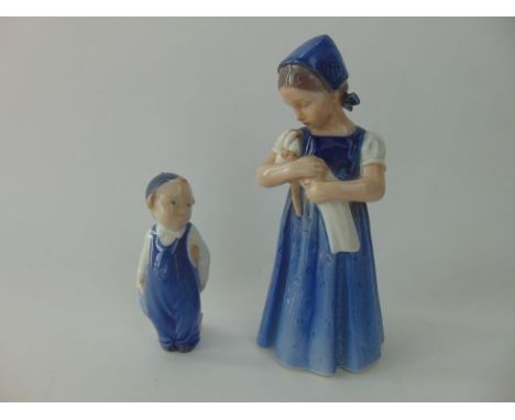 A Royal Copenhagen model of a little girl holding a doll, with printed and painted marks to base numbers 2721 together with a