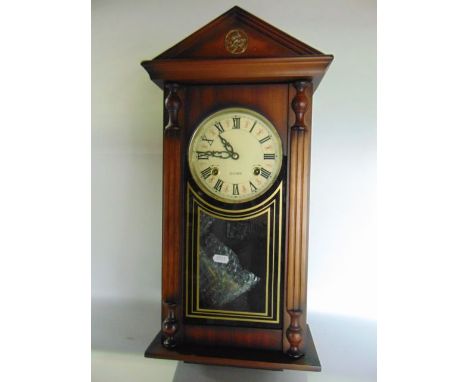 A reproduction wall clock with simulated column supports enclosing a 31-day striking movement beneath an architectural frieze