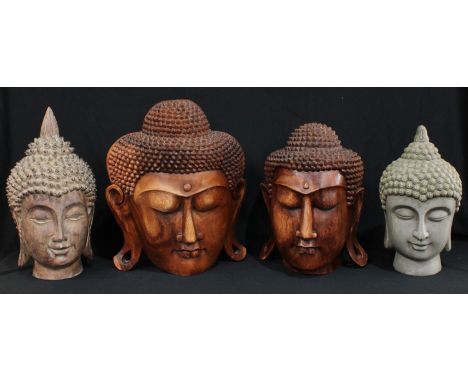 An Indonesian carved wooden bust of The Buddha, 35cm; another similar smaller, 32cm; another carved hardwood; a ceramic bust 