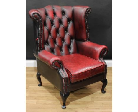 A Chesterfield style wingback armchair, deep-button upholstery, scroll arms, squab cushion, cabriole legs, pad feet, 103cm hi