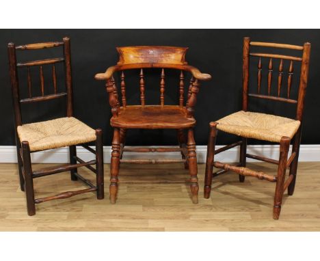 A late Victorian smoker's bow elbow chair, 80cm high, 65cm wide, the seat 38cm wide and 37cm deep; two Lancashire spindle bac