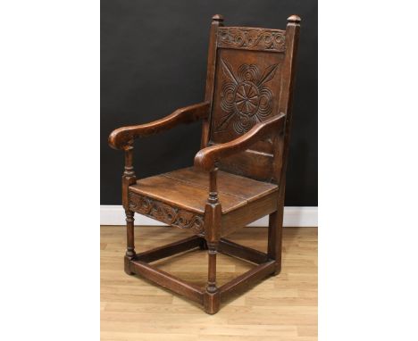 An 18th century oak Wainscot armchair, possibly Cheshire, rectangular cresting rail carved with scrolling acanthus flanked by