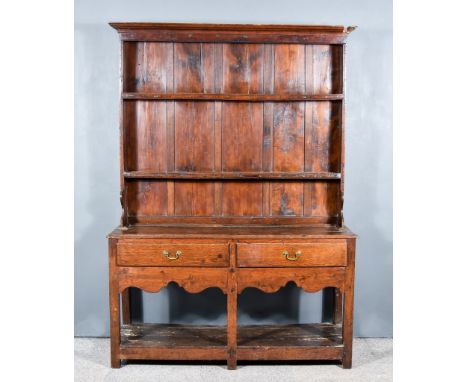 An Old Oak Dresser, the upper part with moulded cornice and open shelves, the base fitted two frieze drawers, on shaped apron