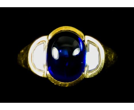 An 18ct Gold Cabochon Sapphire and Diamond Ring, set with a centre cabochon sapphire, approximately 1.5ct, flanked by two sem