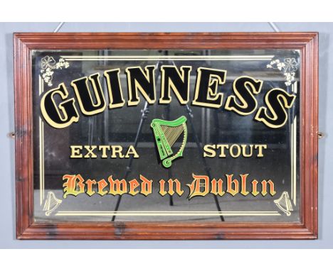 A Modern Stained Wood Framed Advertising Mirror for Guinness, with gilt lettering and harp trademark in green, 26ins x 39ins 