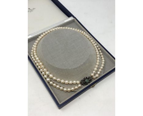 A good quality double strand of pearls with gold, diamond set clasp