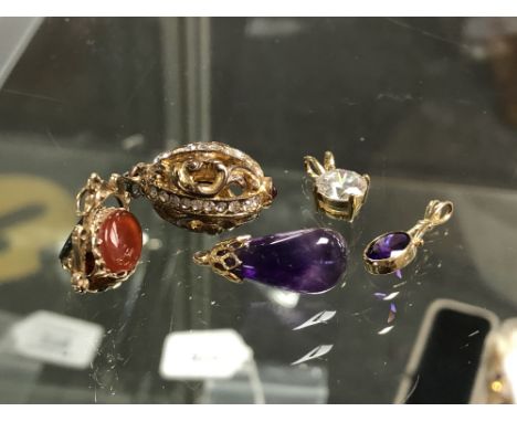 A gold swivel fob set with bloodstone and agate, together with three other yellow metal pendants and a gilt pendant (5)