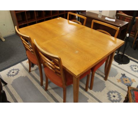 A mid century light oak dining table and four chairs 