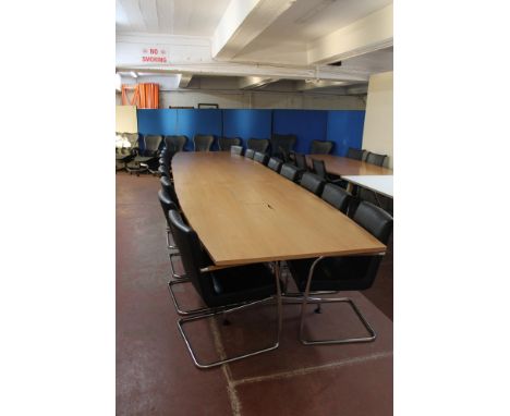 A triple section boardroom table in a walnut finish, length 540 cm, and a set of sixteen Kusch Co black leather armchairs on 
