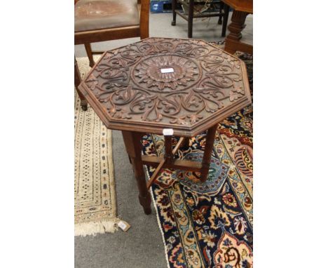 A carved oak folding table 